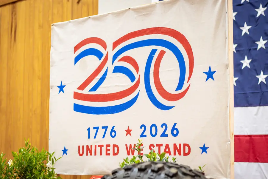 A 1776 to 2026 'United We Stand' banner hung beside an American flag