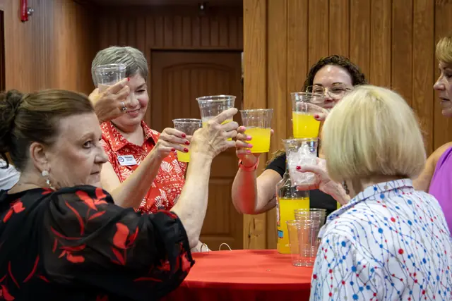 Volunteers raising a toast around a table before the event began